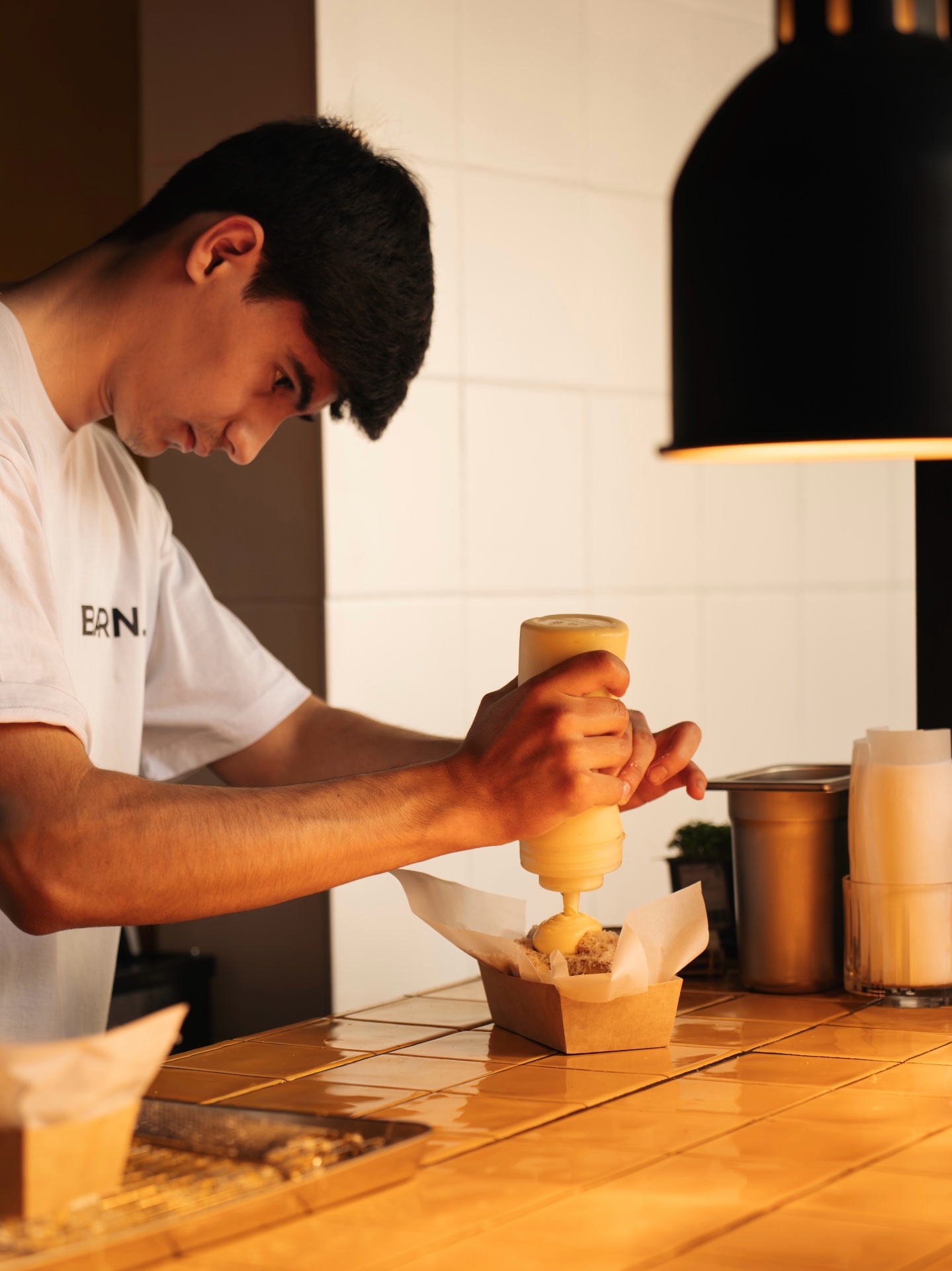 BARN. fries kitchen — sauce being poured over a fresh cone